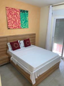 a bedroom with a large bed with red pillows at Immeuble carrefour 2 in Ngaparou