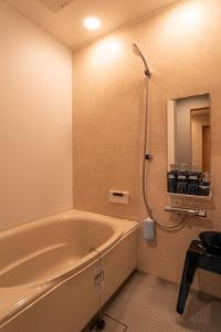 a bathroom with a bath tub and a shower at Tiny House Iyashirochi Kaze in Miyoshi +26 photos