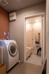 a washing machine in a bathroom with a shower at Tiny House Iyashirochi Kaze in Miyoshi