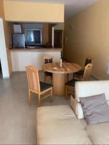 a living room with a table and chairs and a couch at Immeuble carrefour 2 in Ngaparou +5 photos