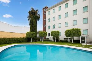 a swimming pool in front of a building at Fiesta Inn Express Perinorte in Mexico City