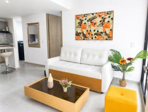 a living room with a white couch and a coffee table at Apartamento Armenia in Armenia +9 photos