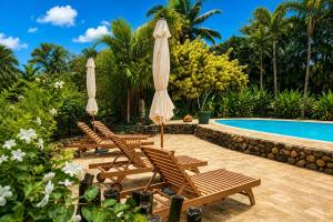 a group of chairs and umbrellas next to a swimming pool at Eco Lodge Village Temanoha in Paopao +49 photos