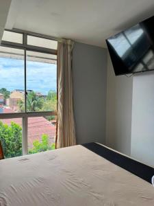 a bedroom with a bed and a large window at Hotel Confort Amazónico in Iquitos