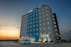 a hotel with a white van parked in a parking lot at One Coatzacoalcos Forum in Coatzacoalcos