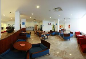 a restaurant with tables and chairs and a bar at One Coatzacoalcos Forum in Coatzacoalcos