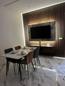 a dining room with a table and a flat screen tv at Appart Hôtel Stade Tanger in Tangier