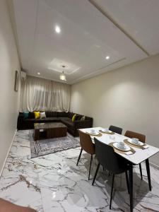 a living room with a table and a couch at Appart Hôtel Stade Tanger in Tangier