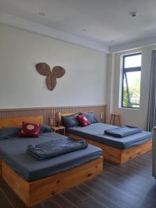 a bedroom with two beds and a window at Homestay Kim Thuy in Hiếu Xương