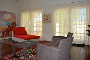 uma sala de estar com duas cadeiras e uma cadeira vermelha em Parrot Villa em Palm-Eagle Beach