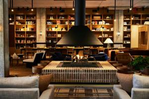 a lobby with a fire pit in the middle of a library at The Junto Hotel in Columbus