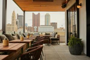 a restaurant with tables and chairs and a view of the city at The Junto Hotel in Columbus