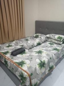 a bed with a flower patterned sheets and pillows at Adeeb Homestay in Tumpat
