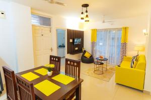a living room with a table and a yellow chair at NK Homes Fully Furnished Apts in Hyderabad