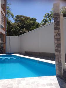 a swimming pool in front of a white fence at Gran Hotel Virrey in San Ramón