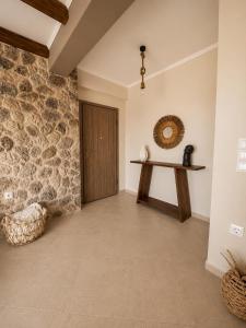 a room with a wooden door and a stone wall at Terra boho apartment in Ambelákia
