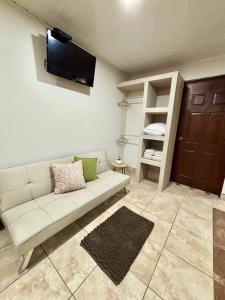a living room with a couch and a tv on the wall at Apartamento Aura 10 in El Coco