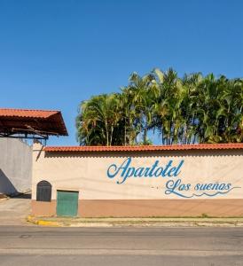 a sign on the side of a building with palm trees at Apartamento Aura 10 in El Coco