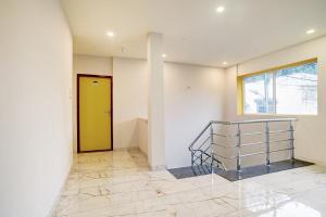 a room with a yellow door and a staircase at Townhouse Pine Tree in Indore +35 photos