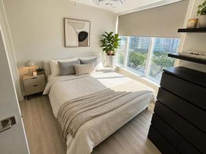 a bedroom with a large bed and a window at Walk Everywhere from This Bright 2BR Condo in Vancouver