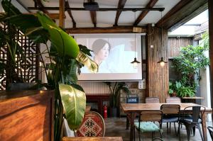 a projection screen in a room with a table and chairs at Peking Station Hostel in Beijing
