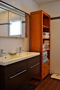 a bathroom with a sink and a shelf with towels at Parrot Villa in Palm-Eagle Beach