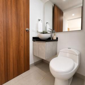 a bathroom with a white toilet and a sink at Edificio Urban in Cajicá +102 photos