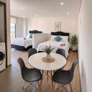 a room with two beds and a table and chairs at Edificio Urban in Cajicá