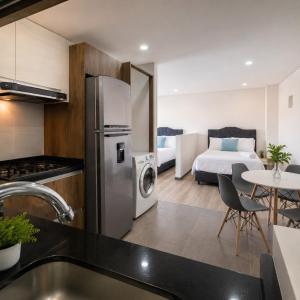 a kitchen with a refrigerator and a bedroom with a bed at Edificio Urban in Cajicá