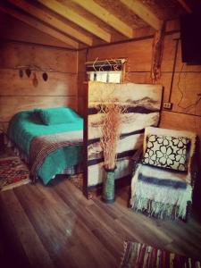a bedroom with a bed and a chair in a cabin at La rustica in Castro