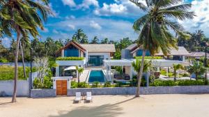 a villa on the beach with palm trees at Masima Samui Villa in Koh Samui