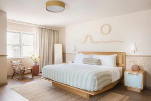 a bedroom with a large bed and a chair at The Ryder Hotel in Charleston +19 photos