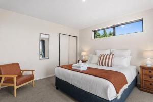a bedroom with a large bed and a chair at Sefton View in Lake Tekapo