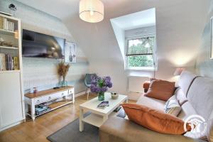 a living room with a couch and a table at La maison verte in Ploeuc