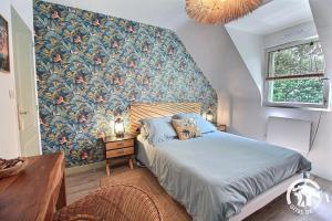 a bedroom with a bed with a floral wallpaper at La maison verte in Ploeuc