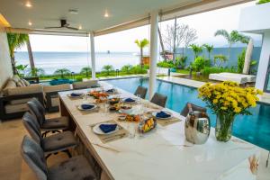 a dining room with a table and a pool at Masima Samui Villa in Koh Samui