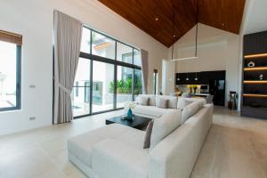 a living room with a white couch and a table at Masima Samui Villa in Koh Samui