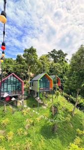 a group of houses in a field with trees at ปลายเขื่อนแคมป์ปิ้ง บ้านแฟมรี่ in Sirindhorn