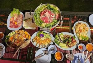 a bunch of plates of food on a table at ปลายเขื่อนแคมป์ปิ้ง บ้านแฟมรี่ in Sirindhorn