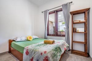 a bedroom with a bed and a window at Casa Dijaweqo in Jimbaran +19 photos