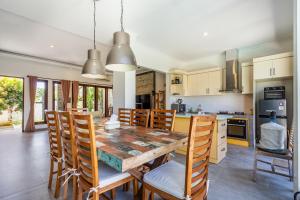 a kitchen and dining room with a wooden table and chairs at Casa Dijaweqo in Jimbaran