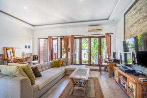 a living room with a couch and a tv at Casa Dijaweqo in Jimbaran