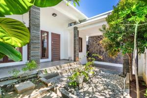 a home with a courtyard with trees and plants at Casa Dijaweqo in Jimbaran