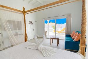 a bedroom with a white bed with a towel on it at Beach Walk Residences in Palm-Eagle Beach +21 photos