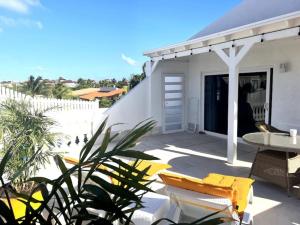 a patio with a table and chairs and a white fence at Beach Walk Residences in Palm-Eagle Beach