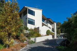 a white house on a hill with trees at Elevated Views Little Kaiteriteri in Kaiteriteri