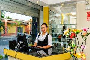a woman sitting at a desk with a computer at Hotel Confort Amazónico in Iquitos
