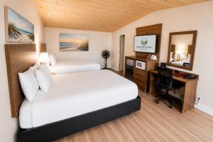 a hotel room with a bed and a desk and a computer at Anchor Bay Inn near Winchester Bay in Reedsport