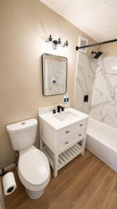 a bathroom with a toilet and a sink and a tub at Anchor Bay Inn near Winchester Bay in Reedsport