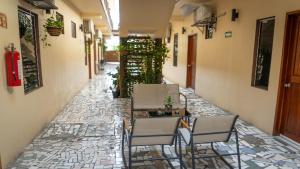 a patio with chairs and a table on a stone floor at Hotel Costa Azul in Chetumal